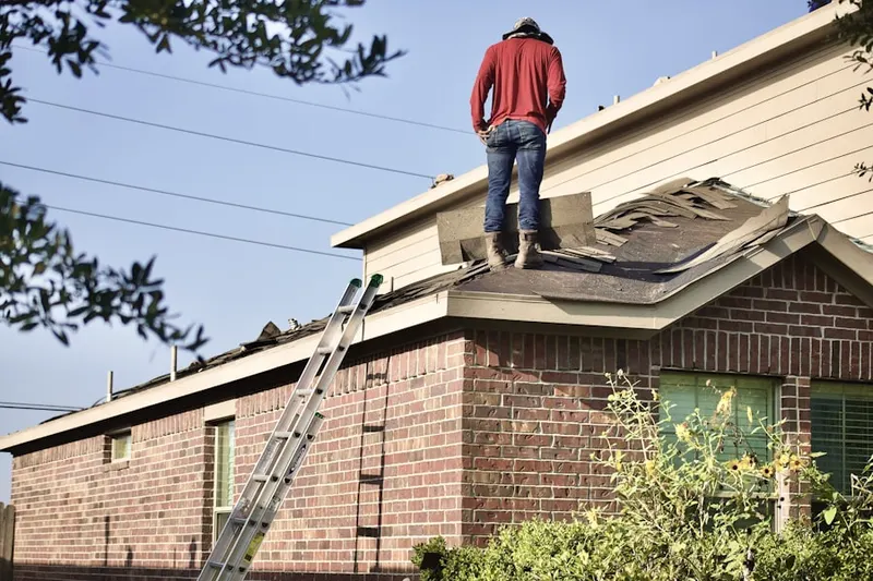 Professional roofer working on a residential roof in Kingsbury Village